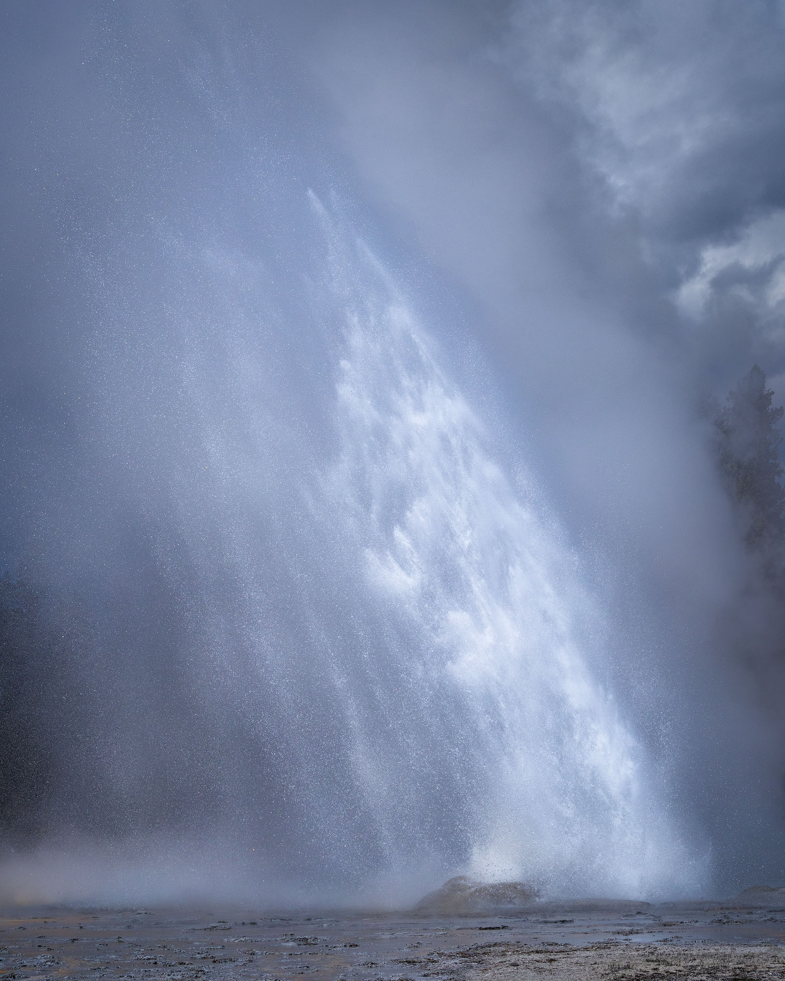 An eruption of Daisy Geyser on a stormy day in. Yellowstone National Park.